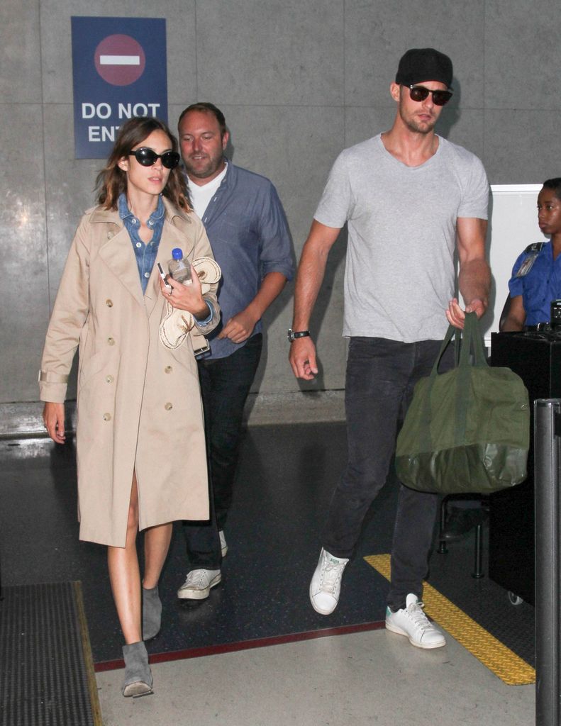 Alexander Skarsgard in gray t shirt and Alexa Chung in trench coat are seen at LAX in 2015
