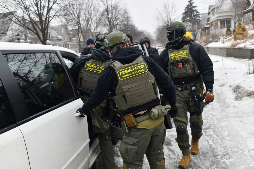Federal agents return to their car after a patrol in the Frogtown neighborhood 