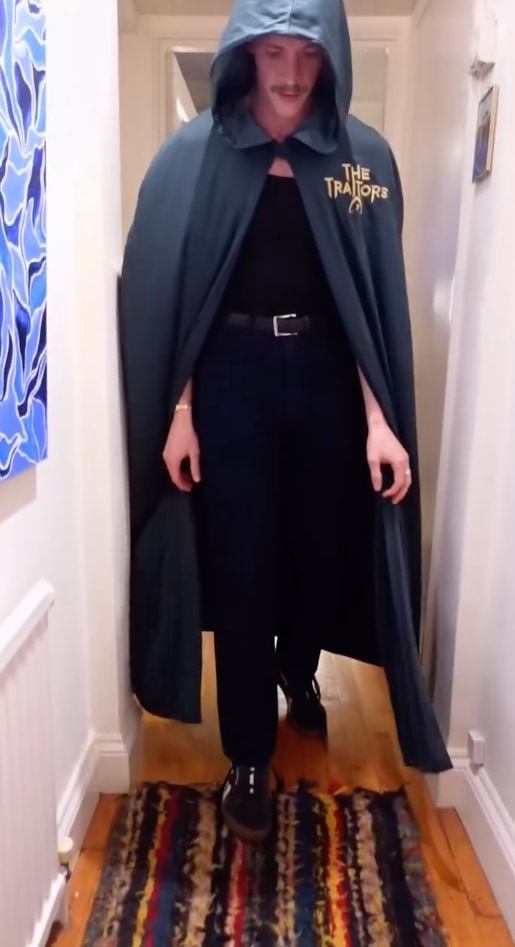 man in hallway in cloak