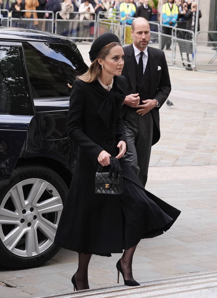 kate ascending steps in black dress
