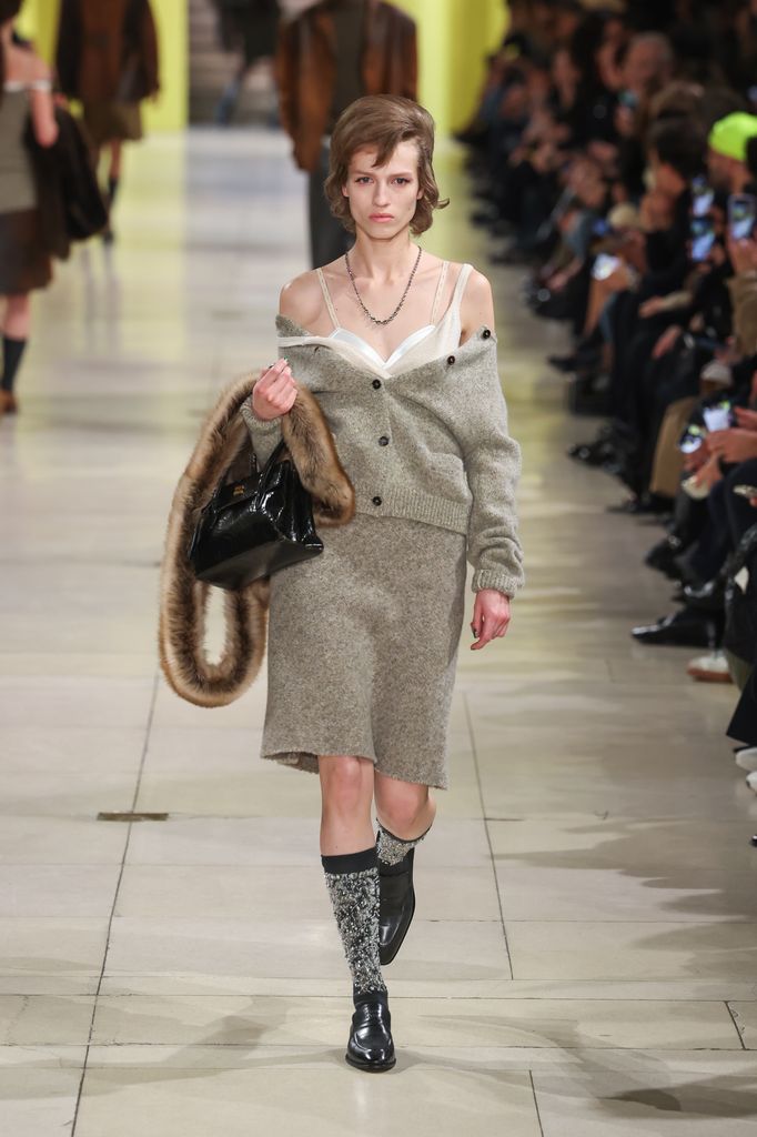 Miu Miu autumn/winter 2025 model wearing knit ensemble and bra
