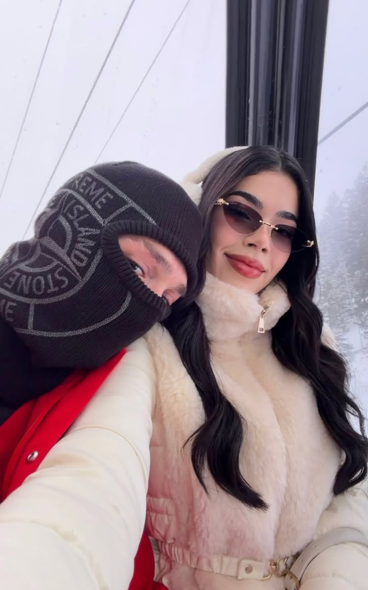 Peso Pluma, known for his bold fashion choices, opted for a striking red ski suit, complemented by a black balaclava, gloves, and snow boots.