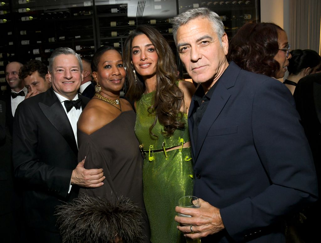 Amal in green dress posed with Ted Sarandos, Netflix Co-CEO, American diplomat Nicole Avant, and her husband