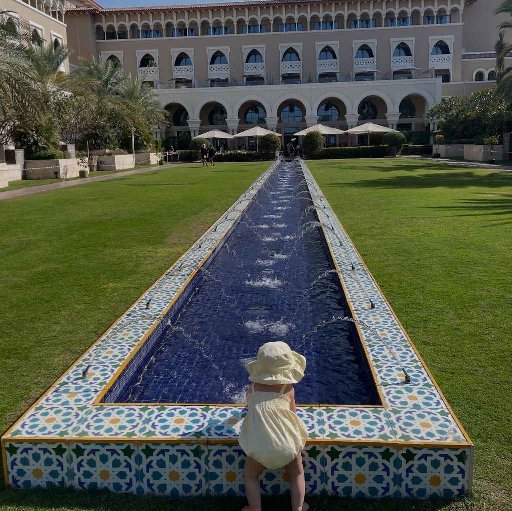 Palma  in a baby romper as she played with a water feature at their hotel