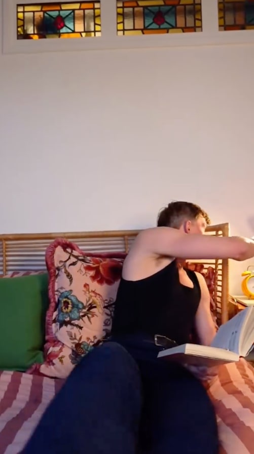 man in bed reading book