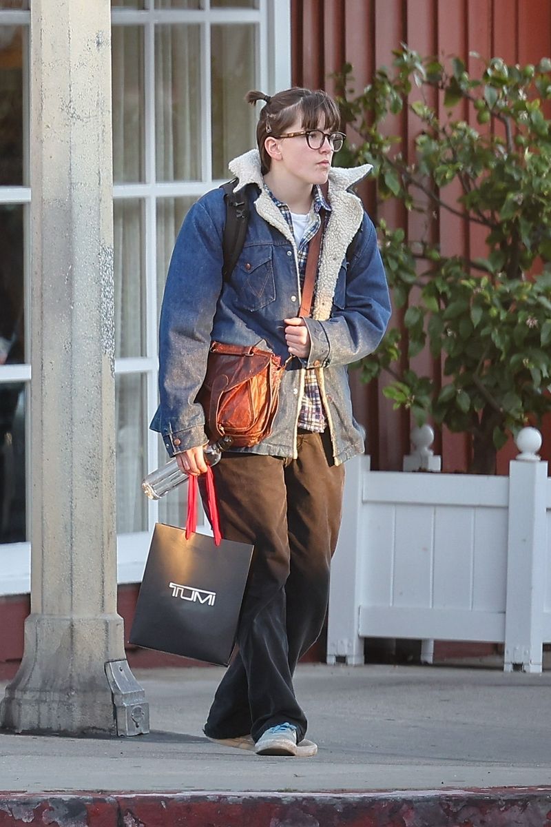 Fin Affleck was spotted in Brentwood playing on a computer near the Big Blue Bus stop, keeping it casual in a denim jacket, brown pants, and Adidas sneakers. 