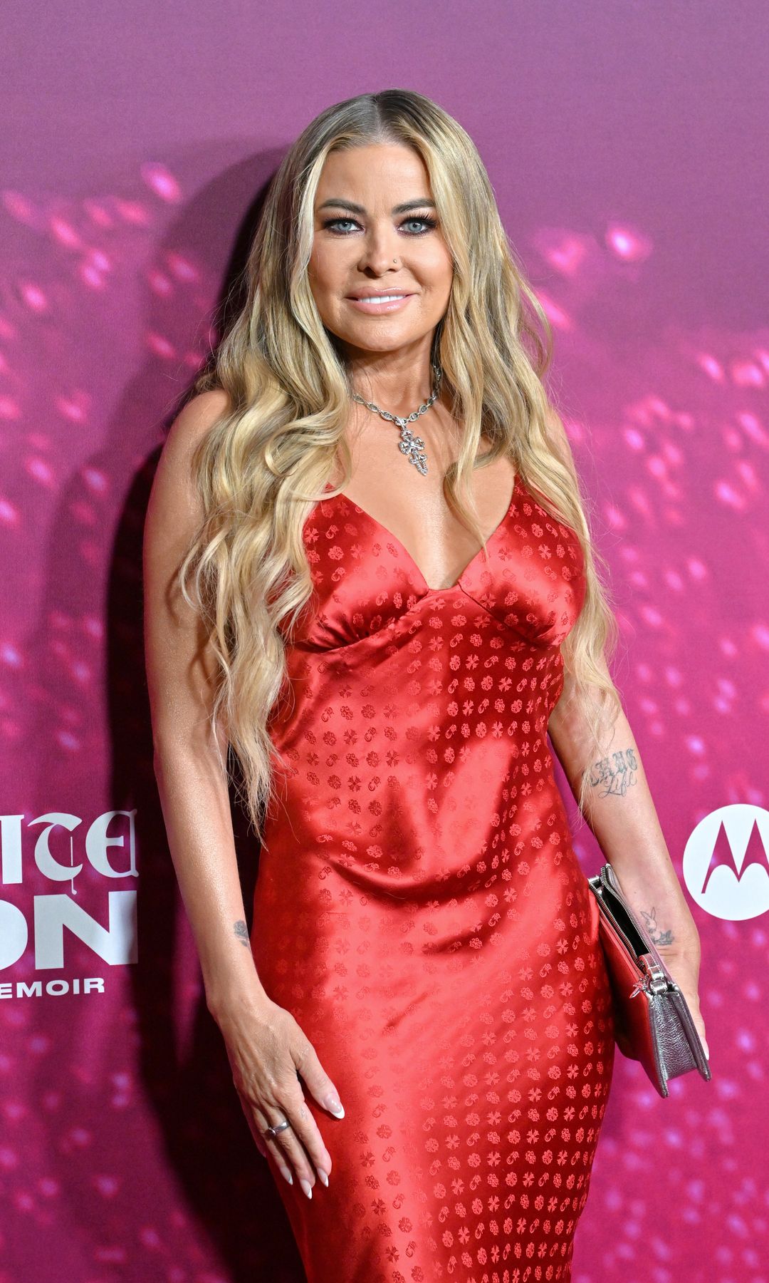 Carmen Electra stuns in plunging red gown as she debuts new back tattoo