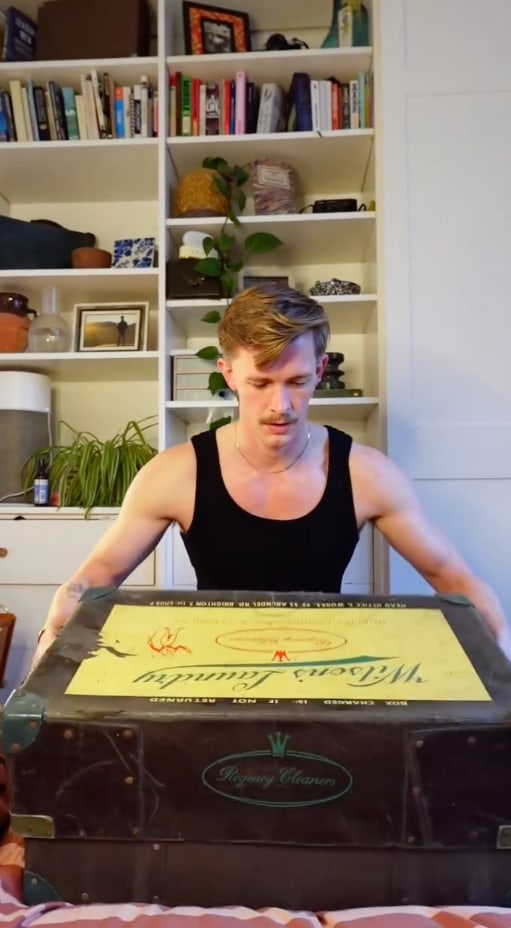 man with chest in bedroom with shelves