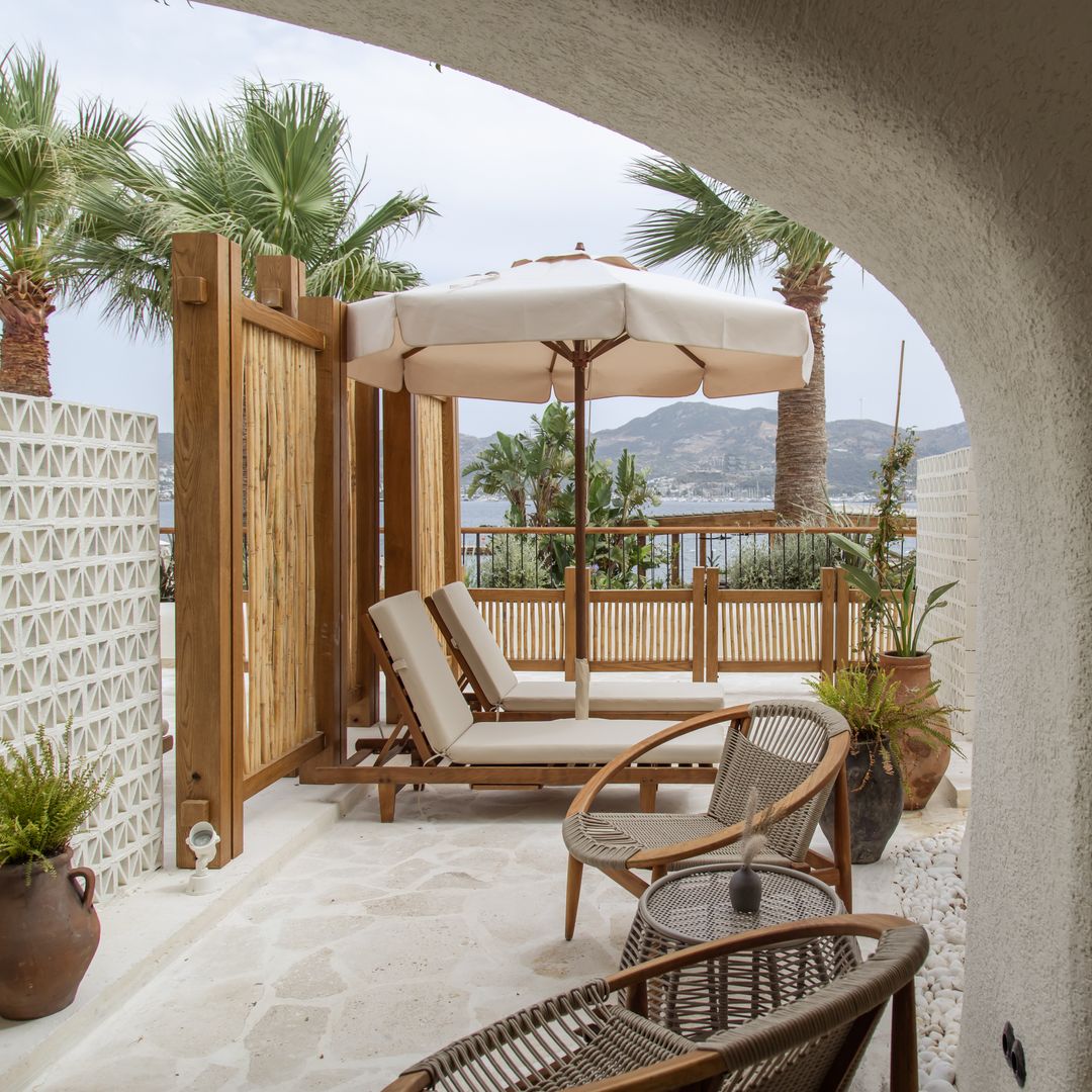 Private terrace at Avantgarde Refined Bodrum with loungers, parasol and sea views in Yalıkavak.