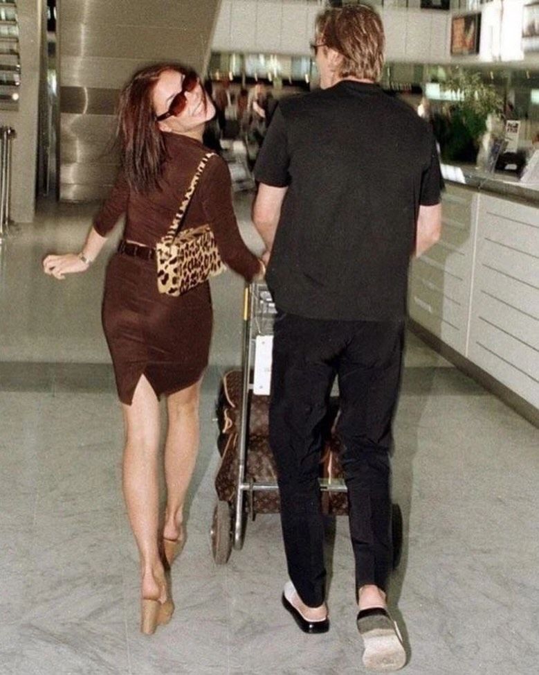 Victoria and david beckham in 90s walking through airport