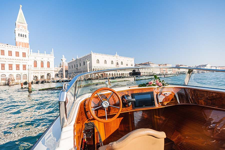A Venice water taxi sails through the canal towards the island