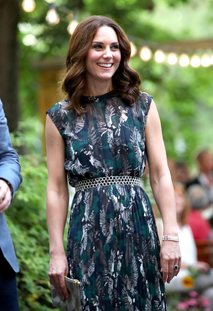 Princess Kate smiling in printed green and blue dress with bob haircut
