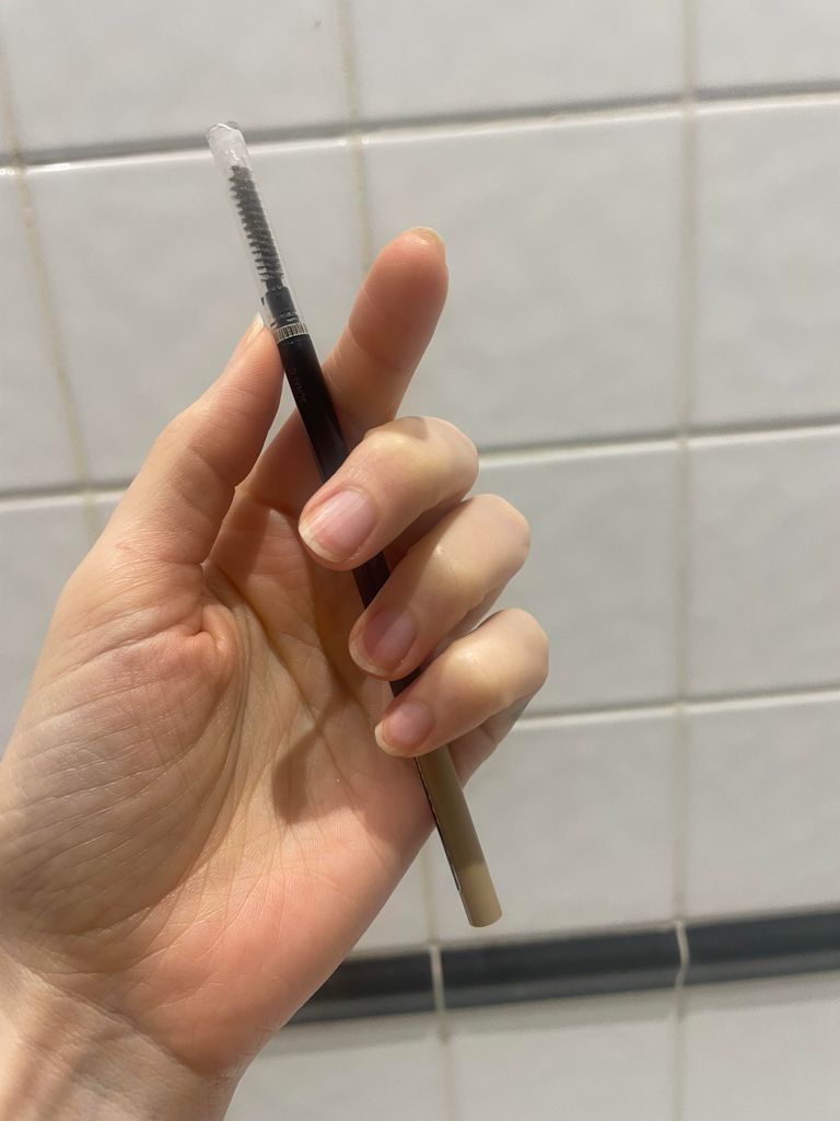 Cassie holding the L'Oreal Paris brow pencil 