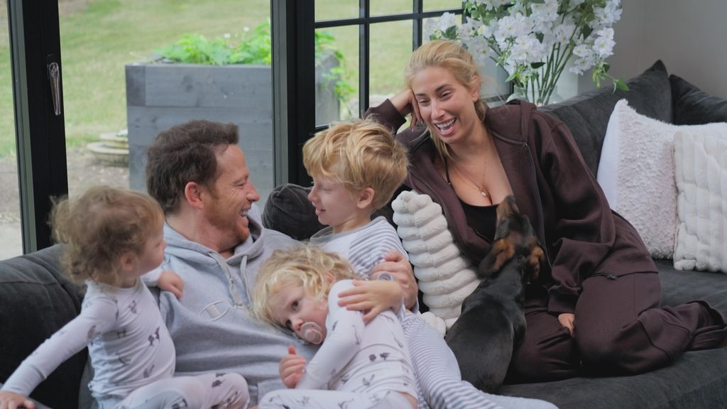 Joe Swash and Stacey Solomon on a sofa with three children a dog