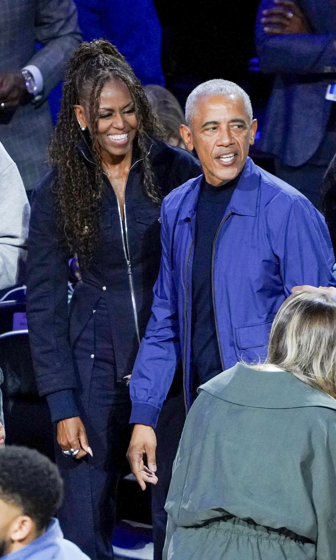 Barack complemented her in a refined yet relaxed ensemble, opting for a deep blue bomber-style jacket layered over a black crewneck shirt, paired with tailored gray trousers. 