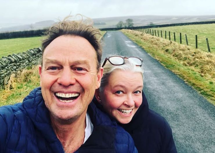 Jason Donovan and wife Angela walking down a country road