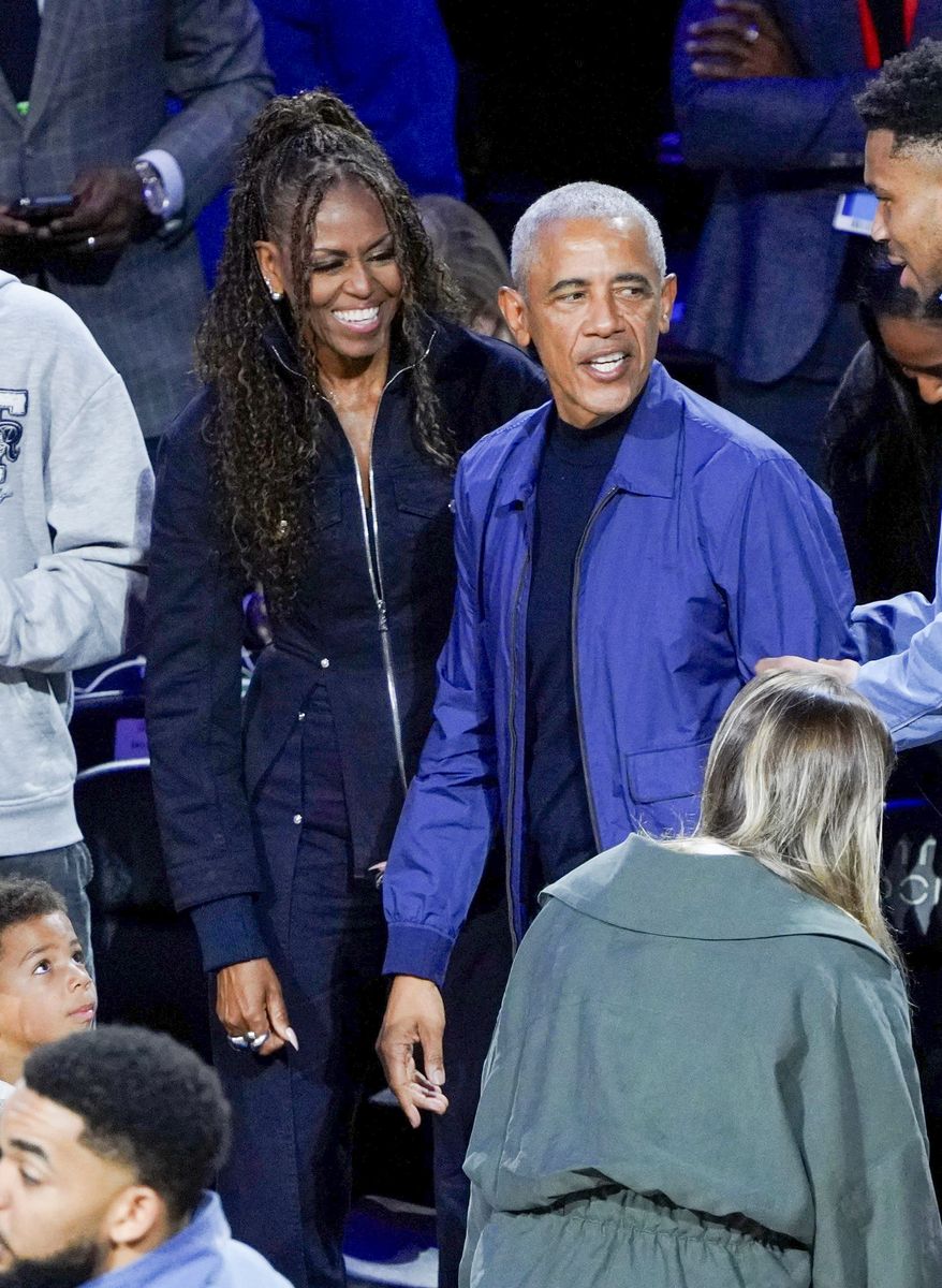 Barack complemented her in a refined yet relaxed ensemble, opting for a deep blue bomber-style jacket layered over a black crewneck shirt, paired with tailored gray trousers. 