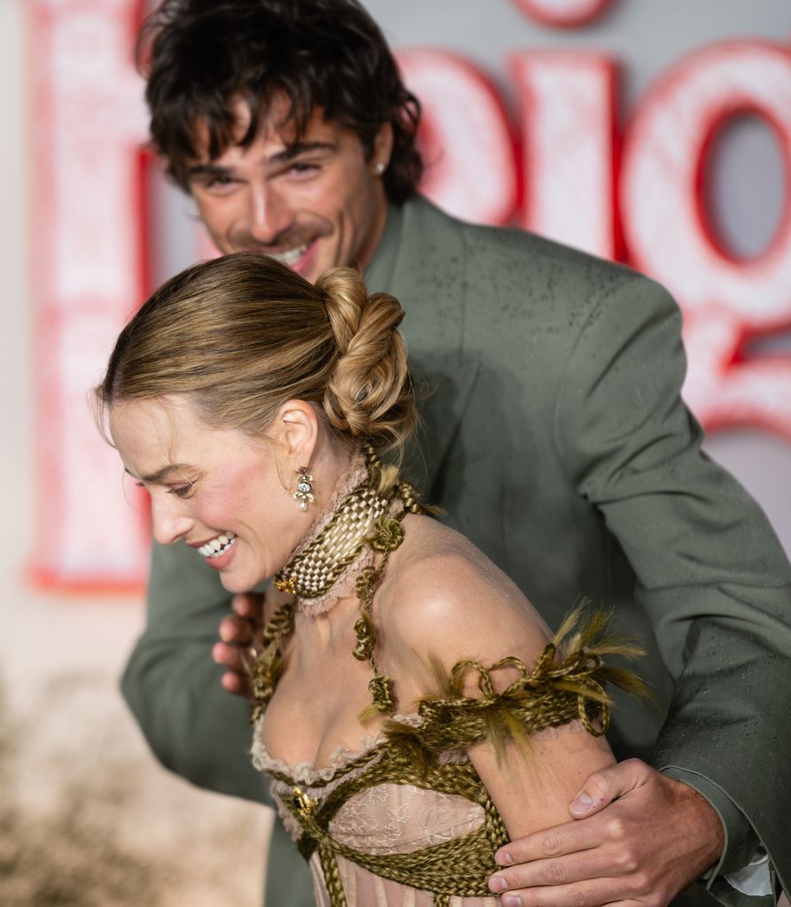 A photo of Jacob Elordi holding Margot Robbie