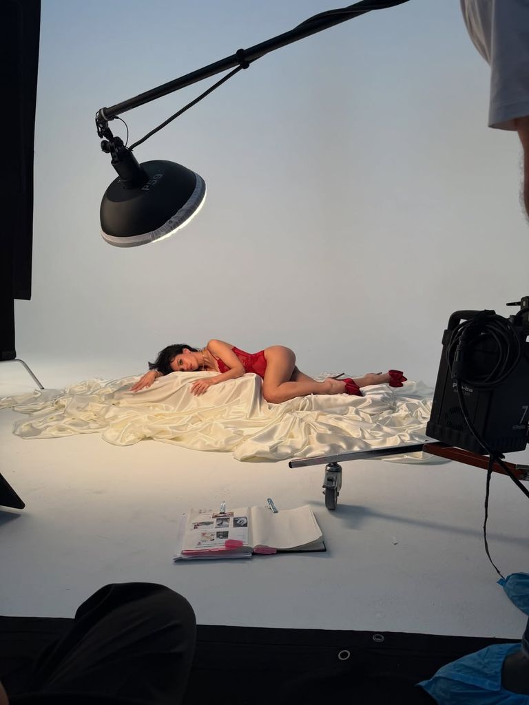 Lily reclines on a white satin sheet 