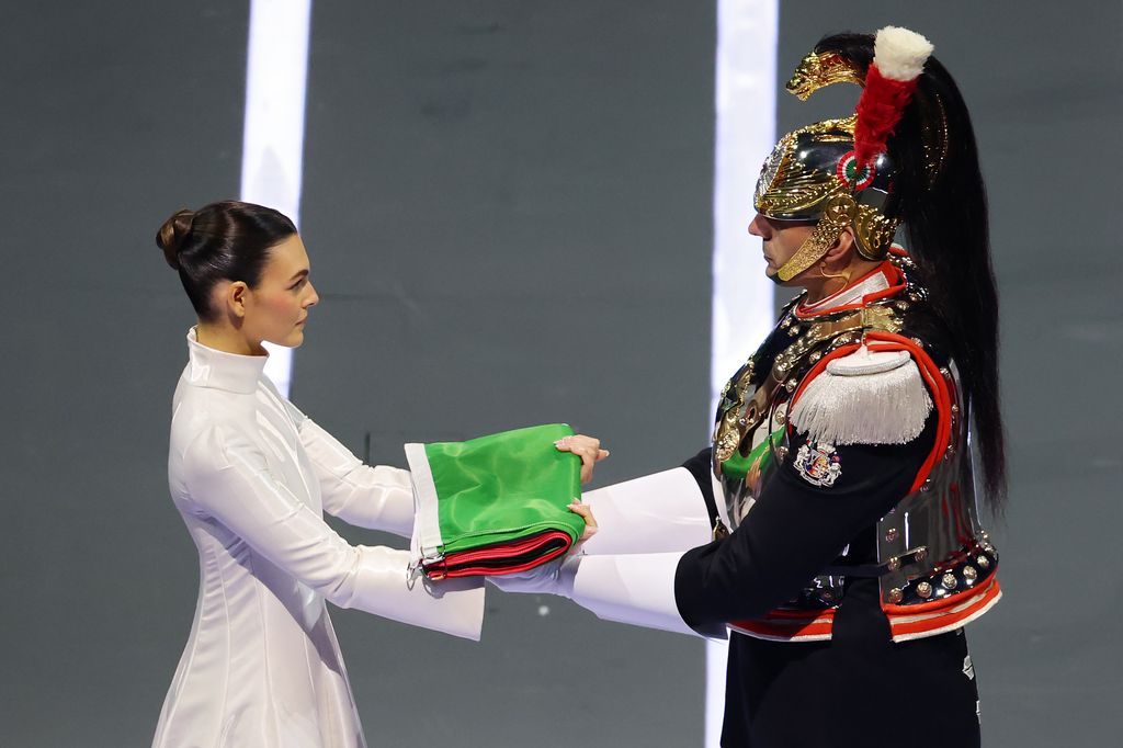 Vittoria Ceretti, flagbearer for Milano, hands the Italian flag to the Corazzieri during the opening ceremony of the Milano Cortina 2026 Winter Olympics
