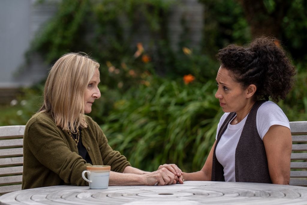 two women sitting at garden table
