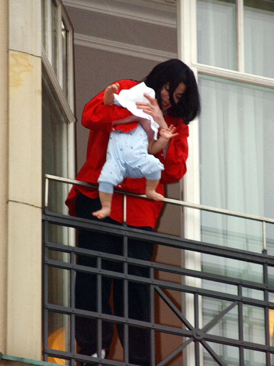 Singer Michael Jackson holds his then eight-month-old son Prince Michael II over the balcony of the Adlon Hotel November 19, 2002 in Berlin, Germany. 