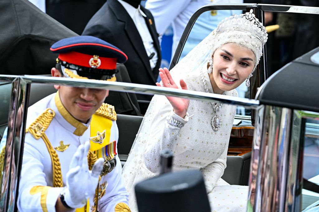 Prince Abdul Mateen and Yang Mulia Anisha Rosnah wave from their car during the wedding procession