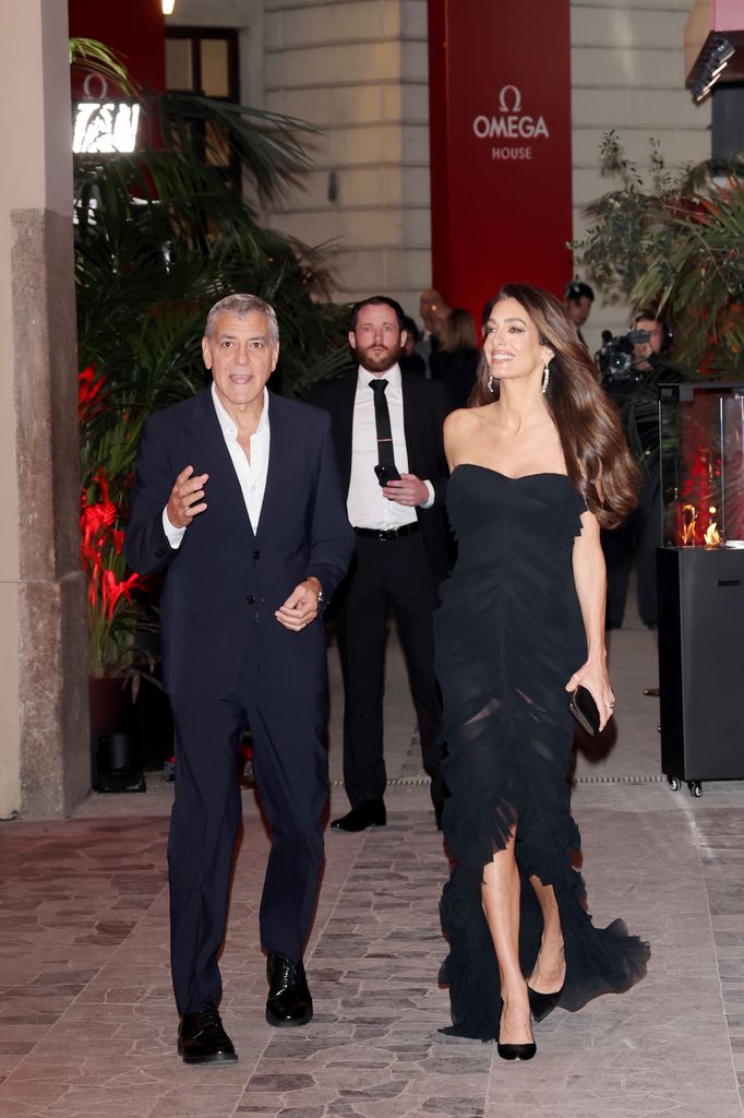 George Clooney in suit and Amal Clooney in black dress in Milan