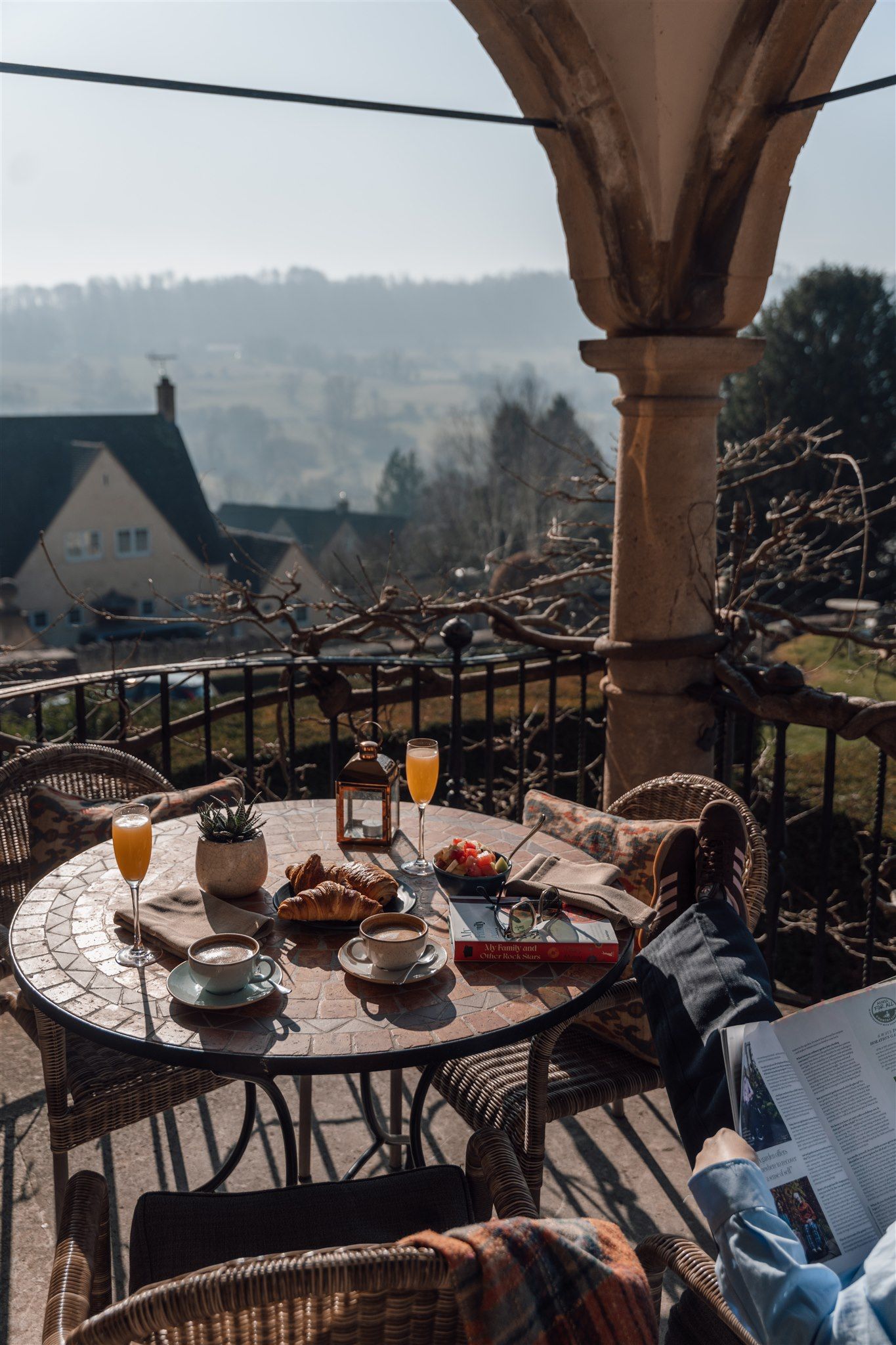 A drinks and snacks set up on a balcony overlooking the English countryside