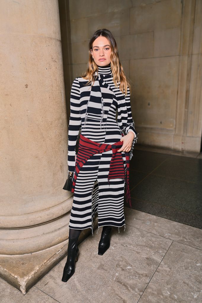 A photo of a brunette woman wearing a monochrome dress