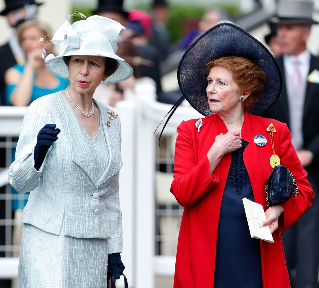 Lady Elizabeth Shakerley in red beside princess anne in pale blue outfit and hat at ascot