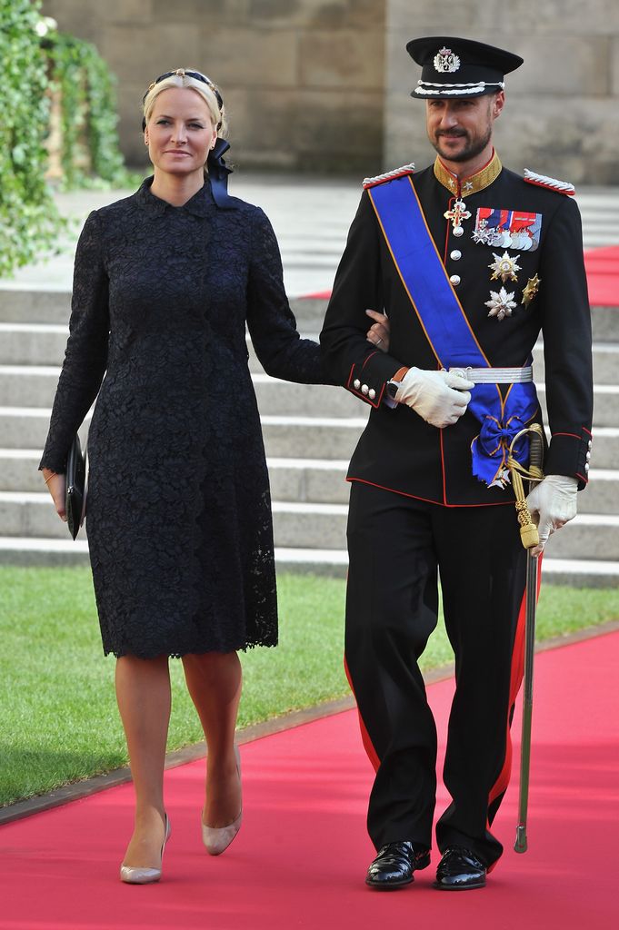 Crown Prince Haakon and Princess Mette Marit on red carpet in formal dress