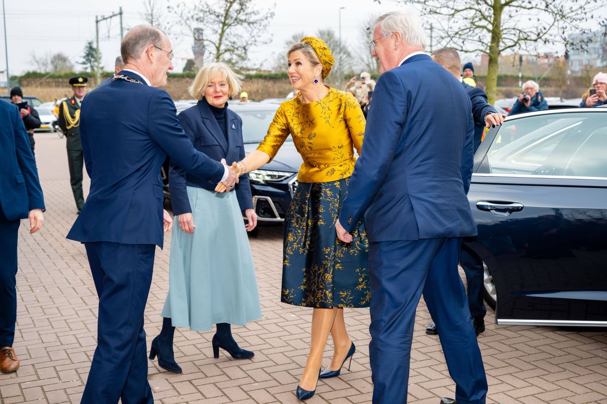 The satin yellow top was paired with a pleated midi skirt in deep navy, creating a striking yet elegant contrast.