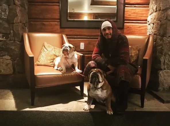 Lewis in wood lodge with two dogs