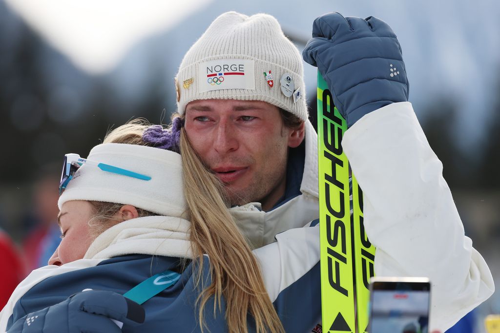 Bronze medalist Sturla Holm Laegreid of Team Norway is embraced by Ingrid Landmark Tandrevold of Team Norway after the medal ceremony where he looks like he has been crying