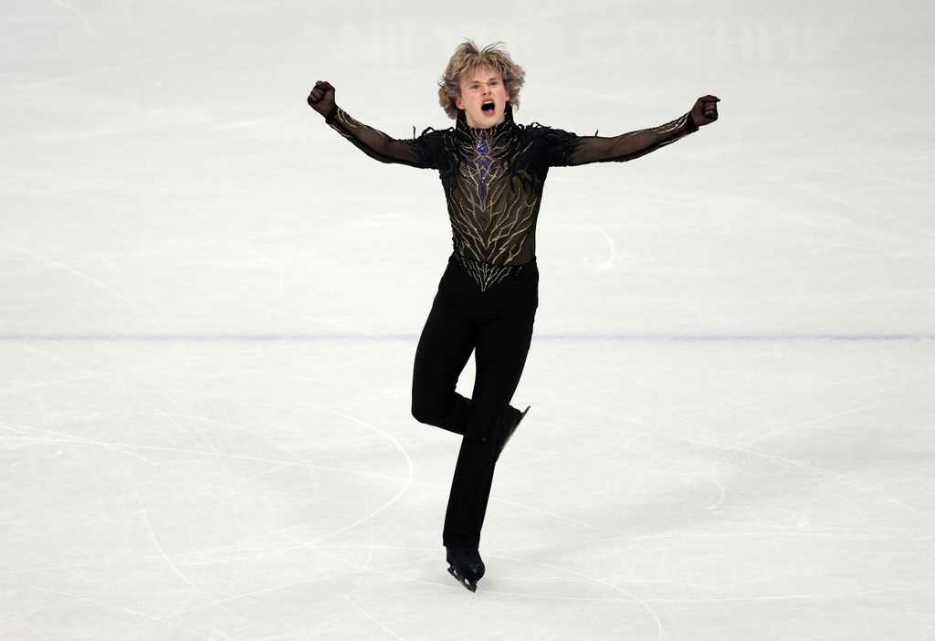 photo of ilia malinin with arms up on the ice