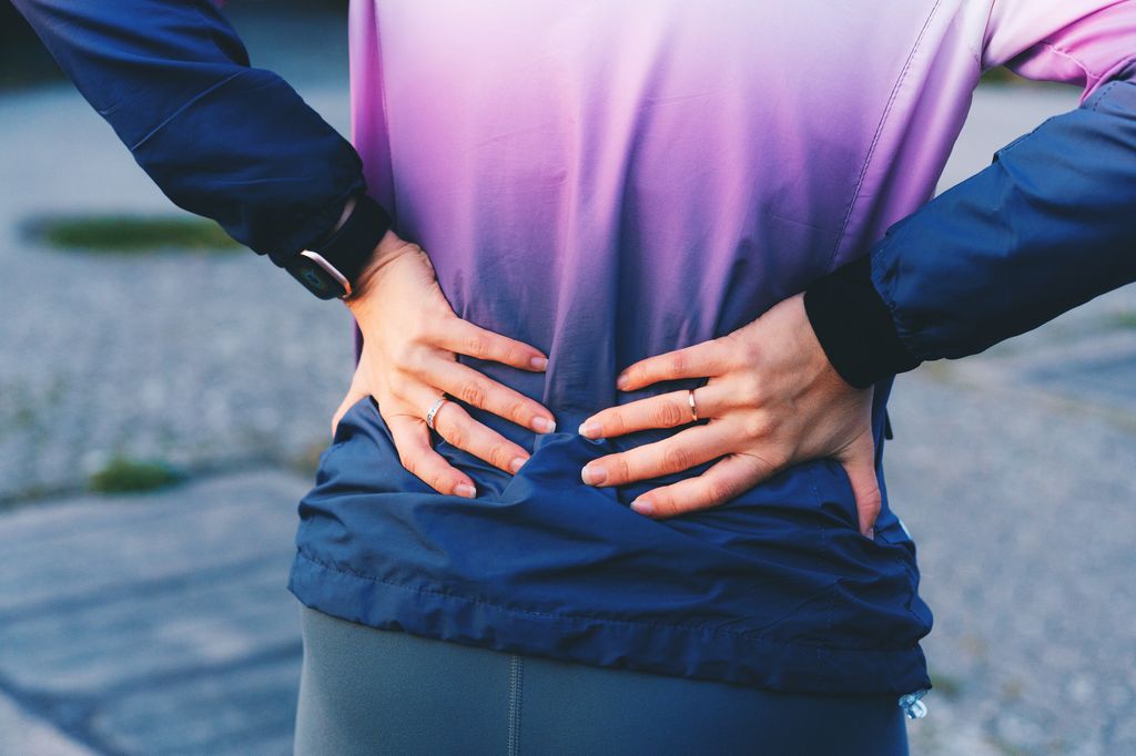 Close-up of woman experiencing lower back pain after exercise