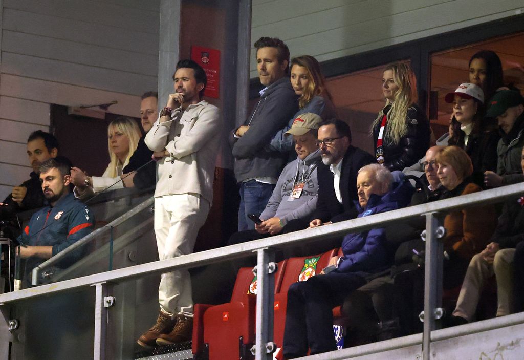 Rob McElhenney looks on as Ryan Reynolds, Actor and Co-Owner of Wrexham, is embraced by his wife and Actress Blake Lively prior to the Emirates FA Cup Fifth Round match 