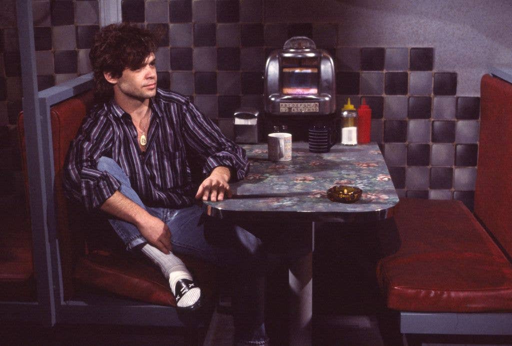 View of American Rock, Country, and Pop musician John Cougar Mellencamp as he sits in a diner booth during an interview on MTV at Teletronic Studios, New York, New York, April 5, 1984.