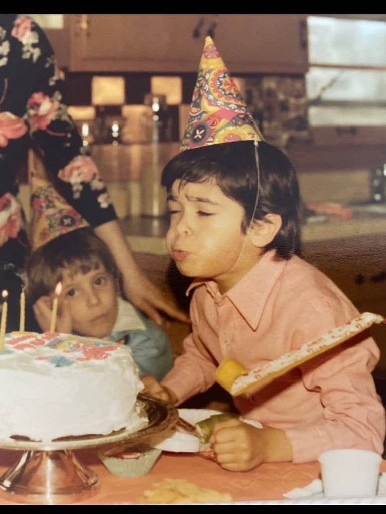 Mark Consuelos as a child blowing out birthday cake