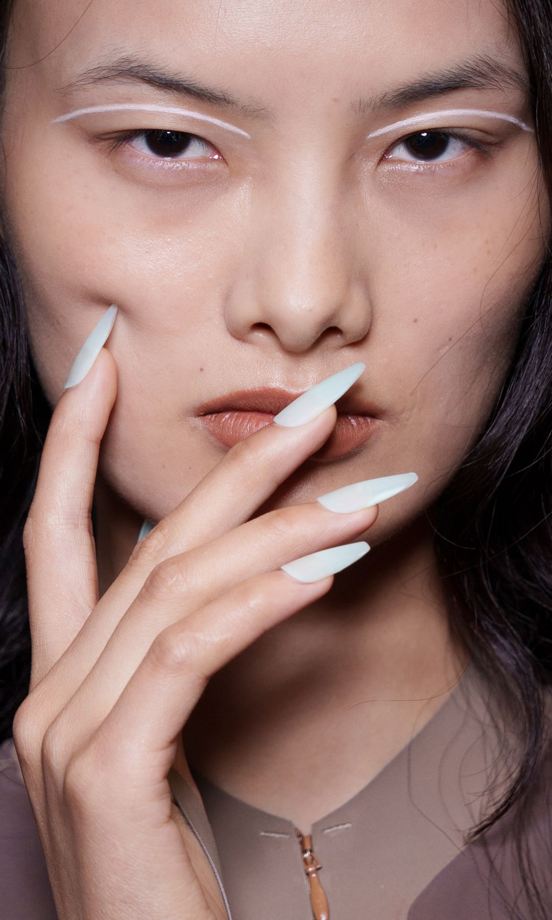 Extra long white nails on a model backstage at the KNWLS show 
