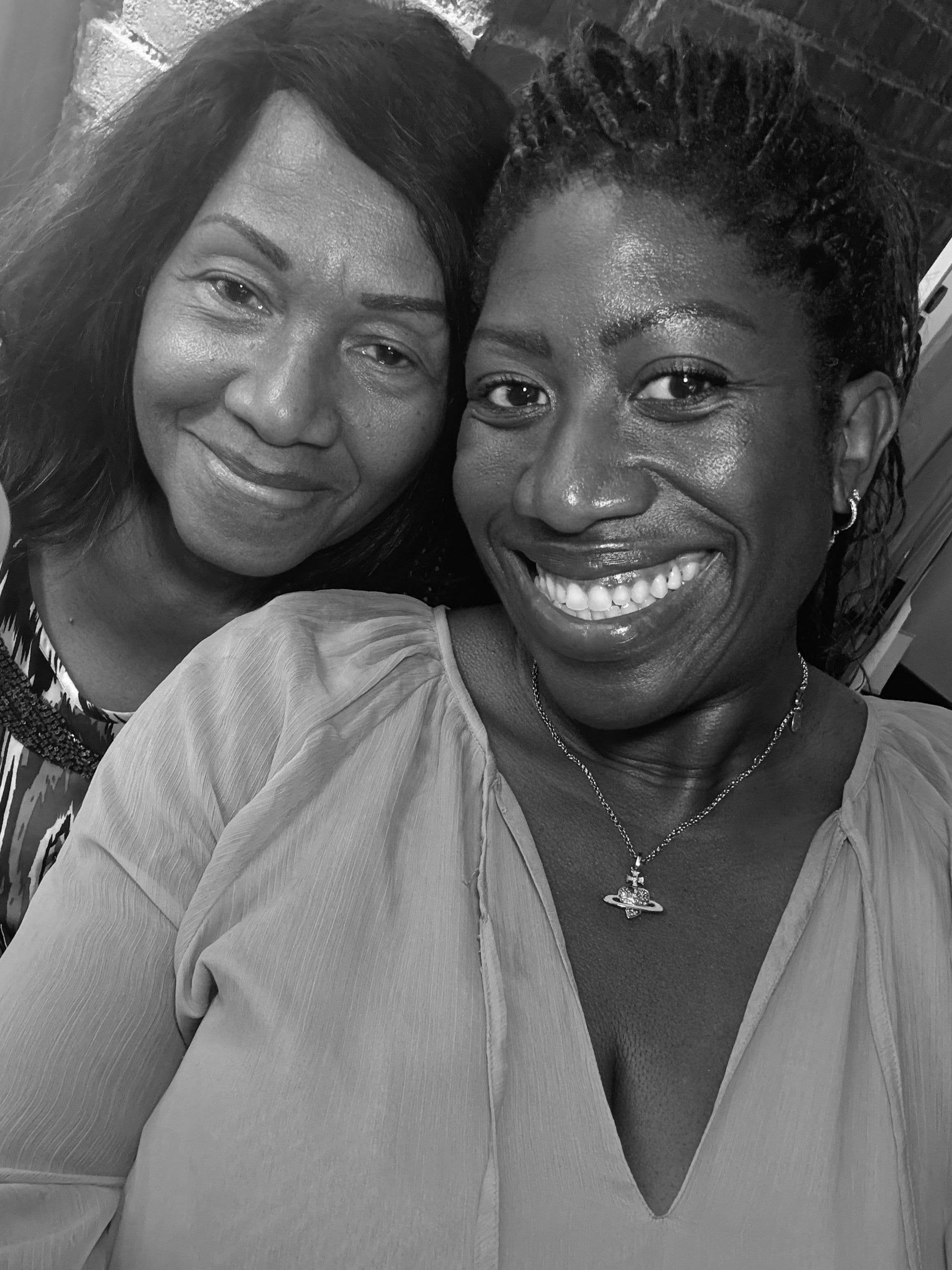 two woman smiling for a black and white selfie 