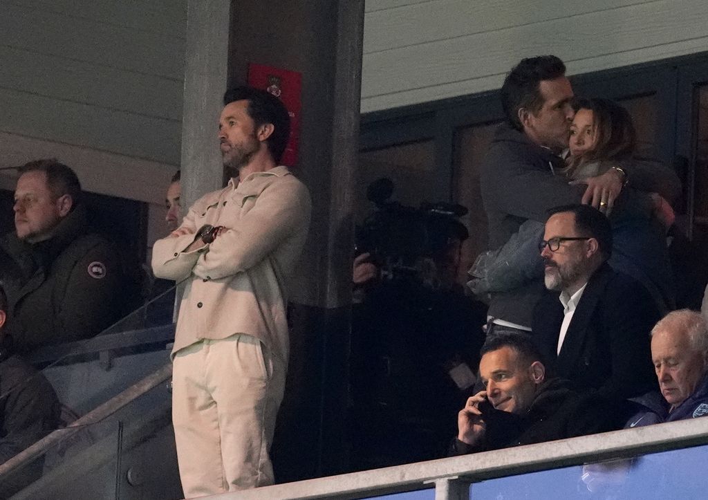 Wrexham co-owner Rob Mac (left) as co-owner Ryan Reynolds (second right) kisses his wife Blake Lively (right) in the stands ahead of the Emirates FA Cup fifth round match at SToK Racecourse, Wrexham