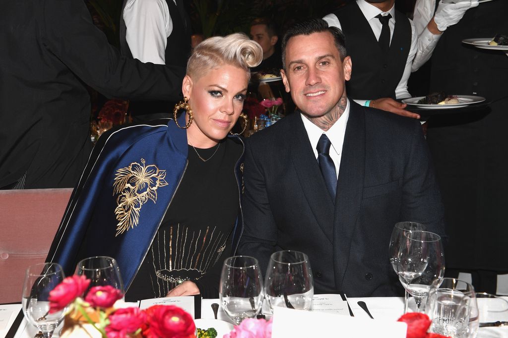 pink sitting at a table with husband carey hart