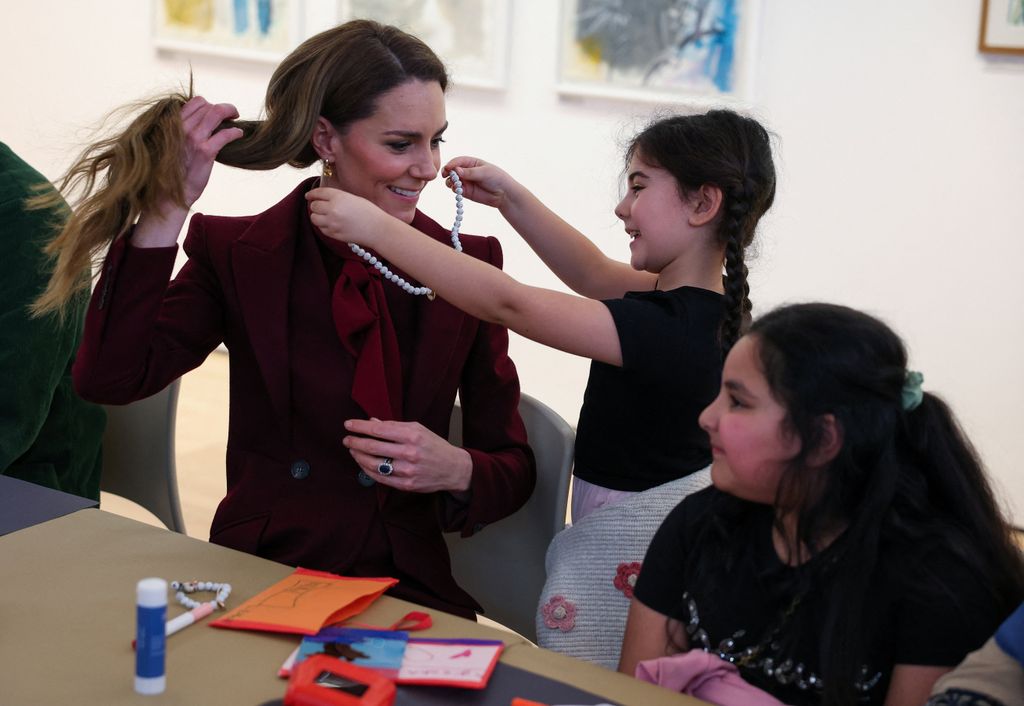 Leman Wetti age 7 gives a necklace to the Princess of Wales, at an art workshop