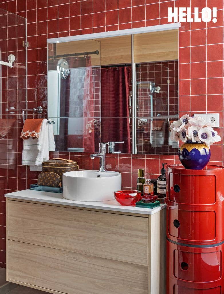 A red tiled bathroom with a sink and mirror inside designer Silvia Tcherassi's Madrid home 