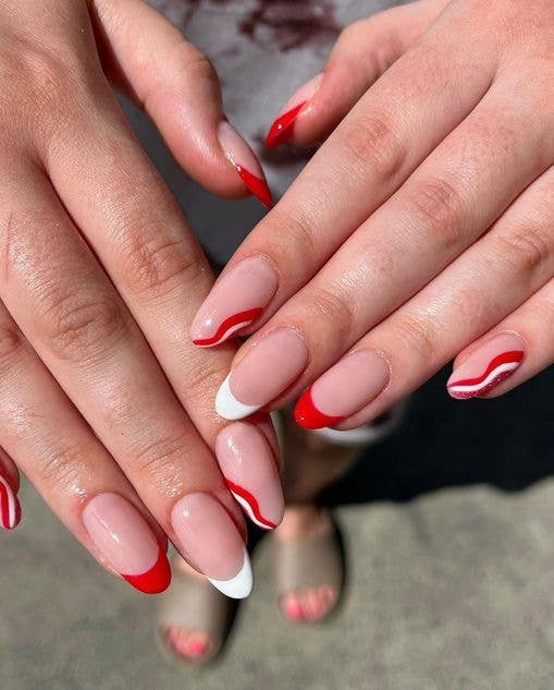 Red and white psychedelic swirl nail art on long pointed nails