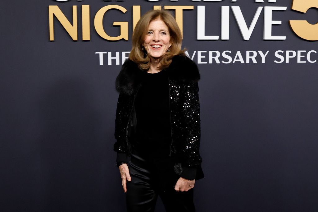 Caroline Kennedy in a black sparkly jacket and black dress smiling at the camera at the 50th anniversary special of SNL.