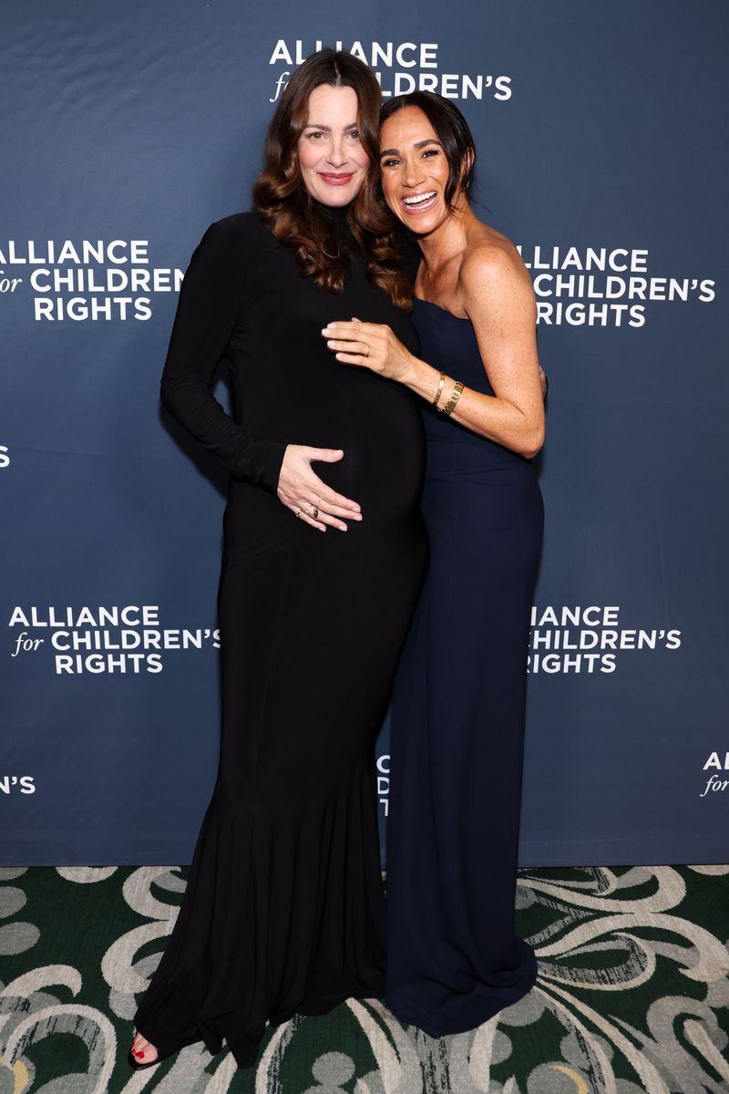 Markle kept her accessories intentionally restrained. She paired the gown with black Stuart Weitzman heels, maintaining a streamlined aesthetic from head to toe.