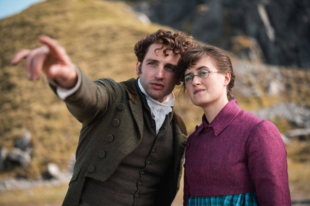 A man points to something in the distance with a woman